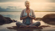 Ältere Frau meditiert und macht Yoga am Strand vor dem Meer