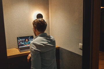 Wall Mural - Male freelancer have a videoconference with colleague while sitting in cozy coworking