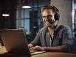 © Kedek Creative - Smiling male office worker wearing headphones in front of laptop working and making a video call