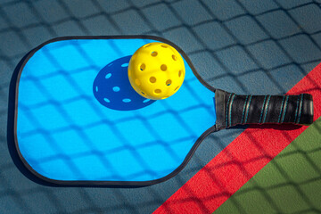 Wall Mural - Blue Pickleball paddle with yellow Pickleball with shadow of Pickleball net.