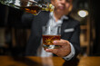 © aekachai - Barman pouring whiskey whiskey glass beautiful night