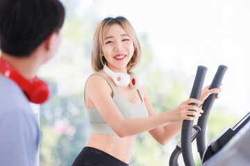 Wall Mural - Asian young fit male female athlete jogger runner in sportswear sport bra legging wear wireless headphones smiling while exercise training on treadmill machine