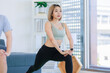 © Bangkok Click Studio - Asian young fit male female husband wife athlete teenager in sportswear sport bra leggings sneakers standing smiling stretching legs warming up on yoga pilates mat together in living room at home