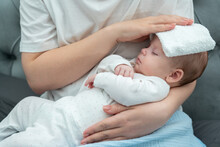 Wet Towel Comforts A Feverish Infant, Concept Of Mother's Instinctive Care Response