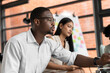 © chachamp - African American businessman working and meeting with team business in office