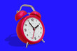 © wowomnom - 3d illustration of red retro alarm clock with arrow with shadow on blue color background