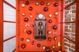 Fototapeta Sypialnia - Red retro phone box with vintage wooden telephone is decorated with Christmas balls. New Year holiday background.