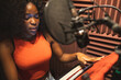 © ADDICTIVE STOCK - Focused black female standing and recording song near microphone equipment in studio