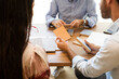 © ADDICTIVE STOCK - Unrecognizable men and woman sitting at table and checking wooden sample pieces in daylight