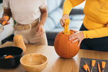 Anonymous Young Women Standing With Orange Pumpkin At Home
