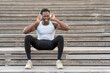 © ADDICTIVE STOCK - Black sportsman in headphones enjoying music on stairs