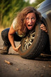 Funny exhausted woman is fixing a car wheel. Generative AI