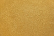 Gold background glitter. Gold sparkling. Glitter particles. Golden color. Noble paper. Gold Coated Paper. Rough surface. Valuable, expensive. Background for designs. Gold paper texture. Gold foil.