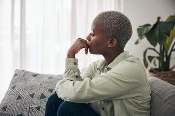 Woman, thinking and depression on sofa for sad memory, mental health risk and anxiety of debt. Stress, worry and lonely african person remember trauma of abuse, broken heart or doubt decision at home