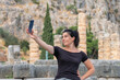 Woman taking a selfie at Delphi area in Greece.
