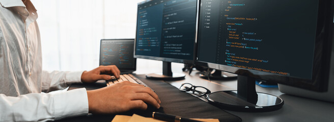 Wall Mural - software engineer working on application development on his computer display code and script on moni