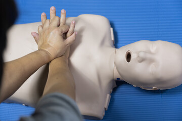 Wall Mural - Demonstrating CPR (Cardiopulmonary resuscitation) training medical procedure on CPR doll in the class.Doctor and nurse students are learning how to rescue the patient.First aid for safe life concept.