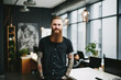 © Jasmina - Confident and smiling handsome hipster man standing in the office