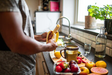 Middle Aged Woman Preparing A Healthy Smoothie Or Shake With Organic Fruits And Vegetables In The Kitchen