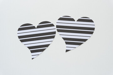 Poster - two black and white striped paper hearts on white