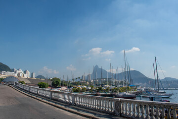 Wall Mural - Rio de Janeiro, Brazil: Urca district, view of Guanabara Bay and the harbour for fishing boats with misty city ​​skyline and Christ the Redeemer on Corcovado Mountain on the background 