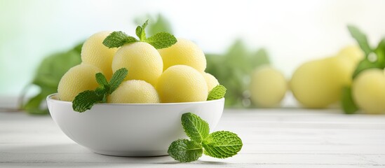 Aufkleber - Closeup of melon balls and mint in a bowl on white wooden table