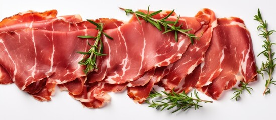 Fototapete - Slices of traditional dried cured pork with fresh herbs on white background top view with space for text