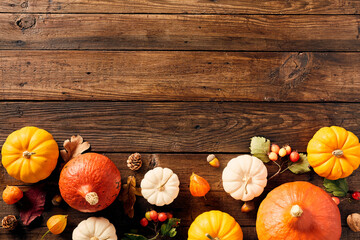 Wall Mural - Happy Thanksgiving greeting card template. Wooden table with colorful pumpkins, fall leaves, acorns, apple, berries. Autumn frame.