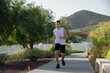 Full lenght image of a young Caucasian boy running. He is wearing sportswear.