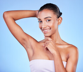 Wall Mural - Armpit, epilation and woman in portrait with beauty, grooming and smile isolated on blue background. Hygiene, cleaning body and hair removal with skincare, cosmetics and dermatology in a studio