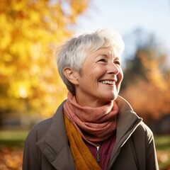 Wall Mural - A woman stands amongst the changing autumn leaves, her warm smile and scarf blowing in the breeze, encapsulating the beauty of the natural world and the joy of the season