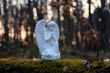 Praying angel figurine in autumn forest, dark natural abstract background. symbol of faith in God, Christianity church, pray, lent, religion concept. Michaelmas day. Autumn season