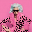 Attractive vamp glamorous lady with lush gray retro style hairdo in pink outfit with animal print and fur.