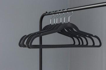 Wall Mural - empty black clothes hanger on gray wall background