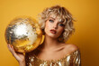 © Viktorikus - Portrait of blonde model woman wearing festive makeup and posing with glitter disco ball on yellow background. Positivity and disco party concept, copy space