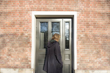 young man opening the front door, warm sunny day