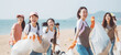 © chiew - Team of diverse volunteer enjoy workers do charitable social work outdoors in cleaning up garbage and waste separation project, at theseaside park background