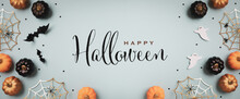 Halloween Holiday Background With Party Decorations From  Pumpkins, Bats, Ghosts, Spider Webs On Blue Top View. Greeting Card With Text Inscription Happy Halloween In Banner Format..