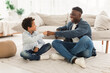 © Prostock-studio - Happy Black Dad and His Kid Son Bumping Fists Indoors