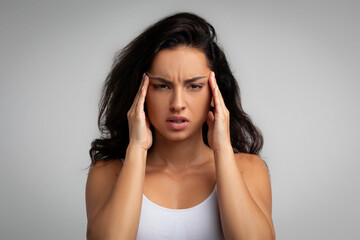 Wall Mural - Sad millennial hispanic woman with long hair touches head