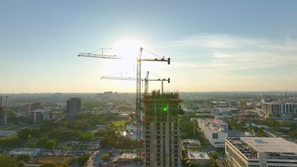 Wall Mural - Aerial view of new developing residense in american urban area. Tower cranes at industrial construction site in Miami, Florida. Concept of housing growth in the USA