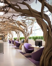 An Office With Purple Chairs And Wooden Trees In The Middle Part Of The Room, There Is A Computer On The Right Hand Side