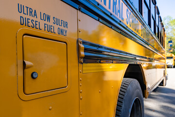 Diesel cap on the side of a parked yellow school bus.