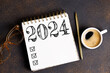 New year resolutions 2024 on desk. 2024 goals list with notebook, coffee cup, plant on table. Resolutions, plan, goals, action, checklist, idea concept. New Year 2024 resolutions, copy space