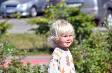 Summer outdoor portrait of a cute blond boy