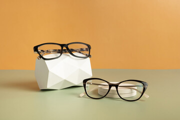 Wall Mural - Gypsum head with eyeglasses on colored background. Optical store, vision test, stylish glasses concept