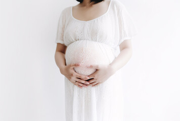 Pregnant woman hugging her tummy on a white background