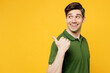 © ViDi Studio - Young smiling happy man wears green t-shirt casual clothes point thumb finger aside indicate on workspace area copy space mock up isolated on plain yellow background studio portrait Lifestyle concept