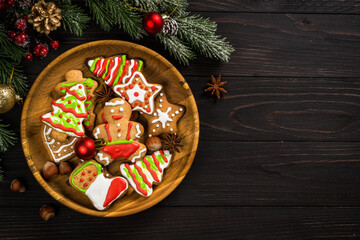 Wall Mural - Christmas gingerbread in the plate with spices and decorations on dark wooden table. Christmas baking. Top view with copy space.