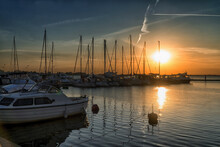 Sunset Over Marina In Summertime. Silhouettes Of Yachts Against The Sky With The Setting Sun.